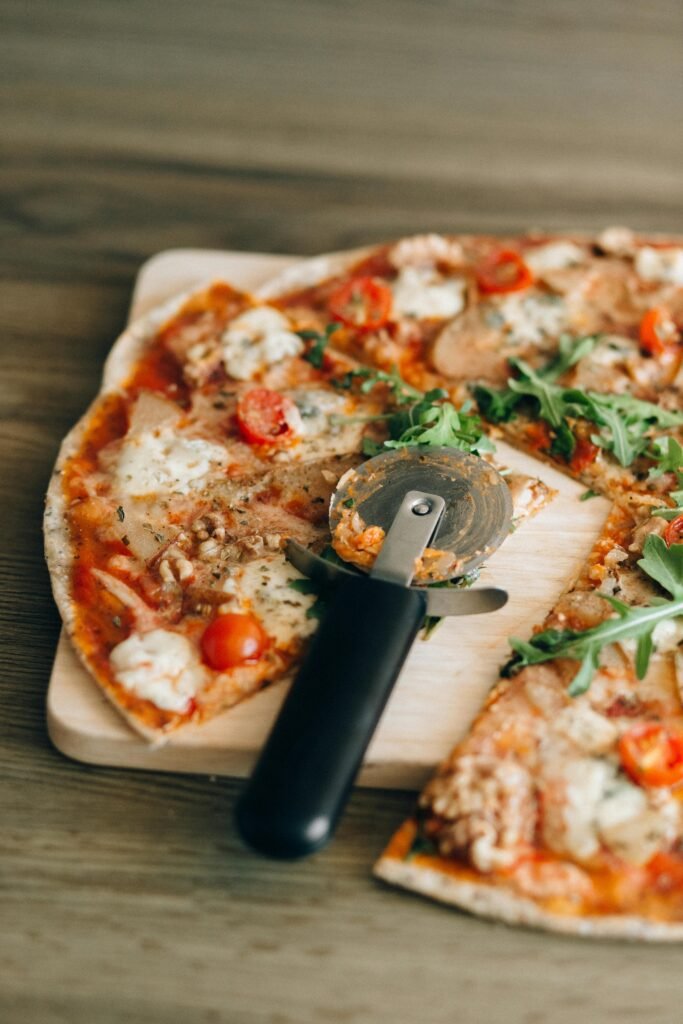Close-up of a pepperoni pizza slice with arugula on a wooden board, perfect for food photography.